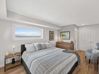 This stunning bedroom offers a serene retreat with its neutral color palette and ample natural light.