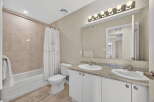 Step into this beautifully designed bathroom, featuring a modern vanity with dual sinks and ample storage.