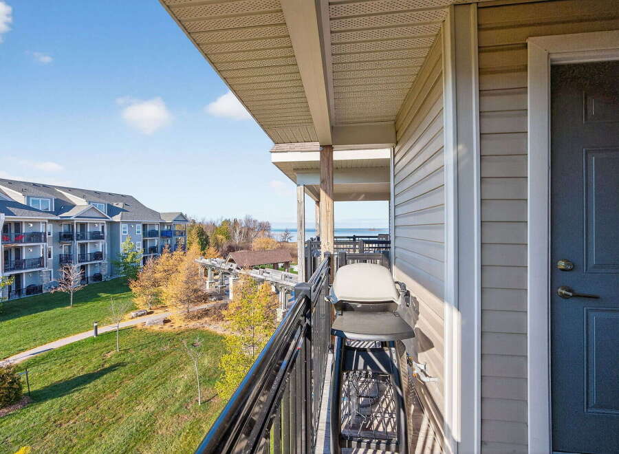 Enjoy stunning views from this beautiful condo balcony! This property features a modern grill, perfect for outdoor cooking and entertaining.