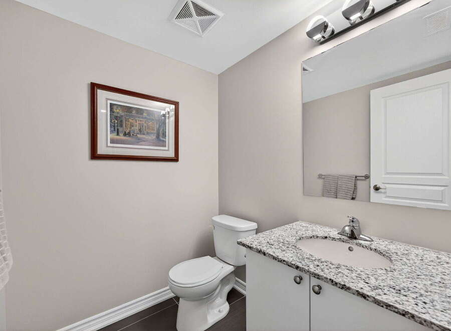 Step into this beautifully designed bathroom, featuring a stylish vanity with a granite countertop and a modern sink.