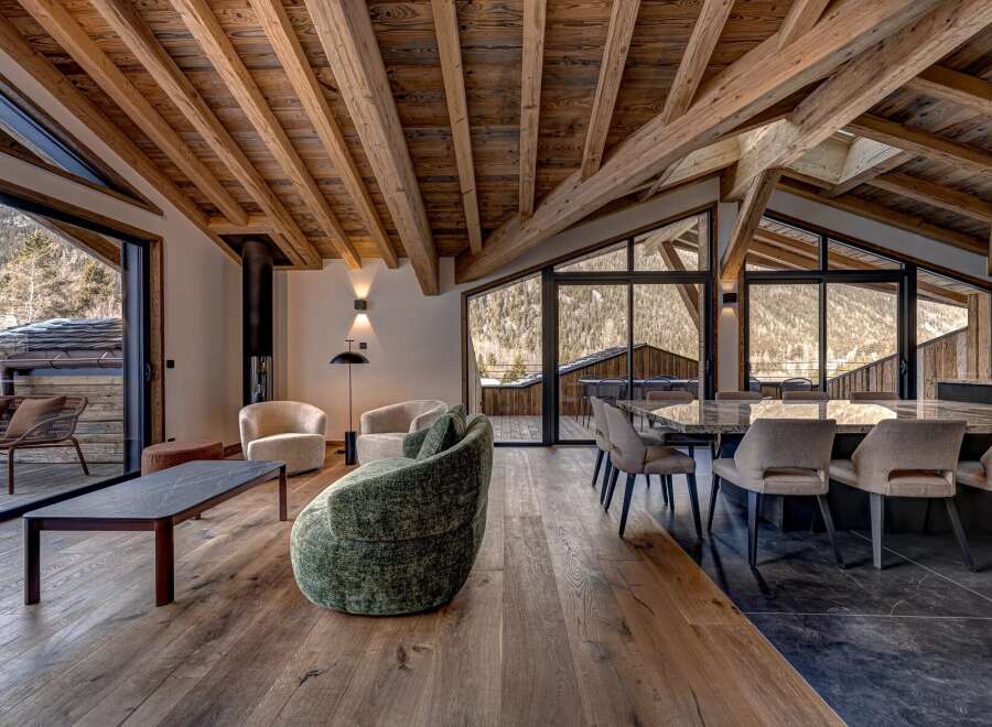 Experience luxury living in this stunning chalet, featuring a spacious open-plan design with exposed wooden beams and large windows that offer breathtaking mountain views.