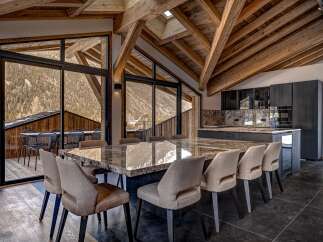 Experience luxury living in this stunning property featuring a spacious dining area with a large marble table and comfortable seating.