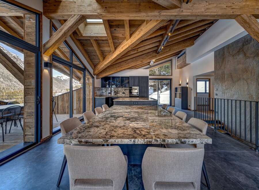 Experience luxury living in this stunning property featuring a spacious dining area with a large granite table and comfortable seating.