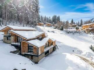 Discover the epitome of alpine luxury in this stunning chalet nestled amidst a snowy landscape.