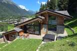 Experience luxury mountain living in this stunning chalet, featuring expansive glass windows that frame breathtaking alpine views.