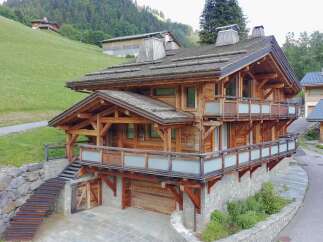 Experience luxury mountain living in this stunning wooden chalet, featuring expansive balconies with frosted glass railings and breathtaking forest views.