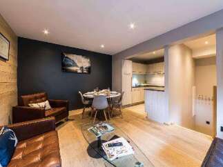 Discover the charm of this beautifully designed property, featuring a cozy living area with comfortable leather seating and a stylish glass coffee table.