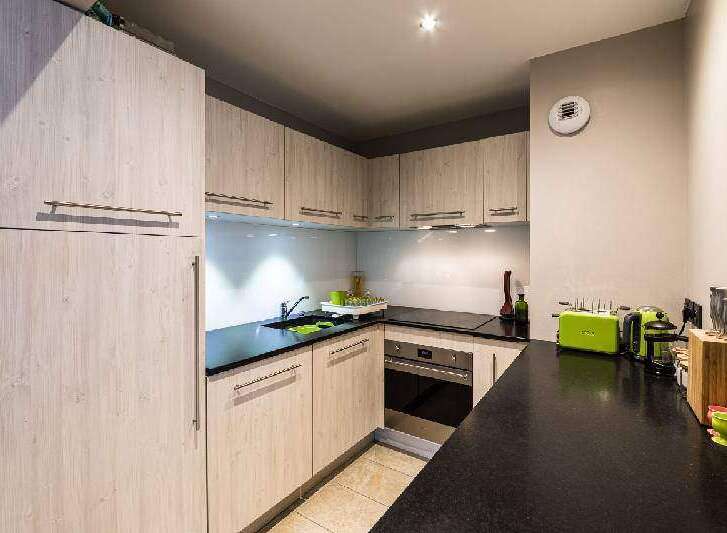 This modern kitchen boasts sleek cabinetry and a functional layout, perfect for culinary enthusiasts.