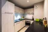 This modern kitchen boasts sleek cabinetry and a functional layout, perfect for culinary enthusiasts.