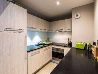 This modern kitchen boasts sleek cabinetry and a functional layout, perfect for culinary enthusiasts.