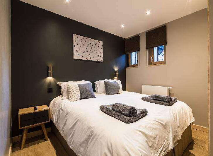 This cozy bedroom features a comfortable bed with soft linens and decorative pillows, perfect for a relaxing stay.