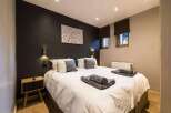 This cozy bedroom features a comfortable bed with soft linens and decorative pillows, perfect for a relaxing stay.