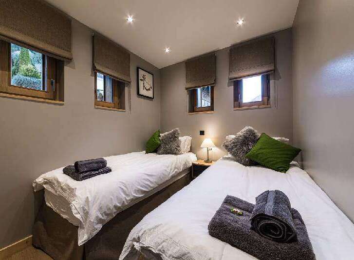 This cozy bedroom features two twin beds, perfect for guests or family.