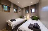 This cozy bedroom features two twin beds, perfect for guests or family.