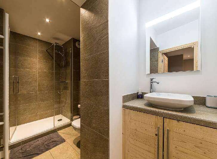 This modern bathroom features a sleek shower with glass doors and a stylish vanity.