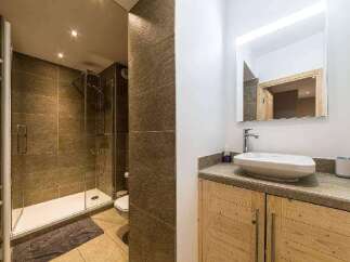 This modern bathroom features a sleek shower with glass doors and a stylish vanity.