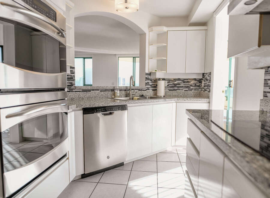 This stunning kitchen boasts modern stainless steel appliances, including a built-in oven and dishwasher, perfect for culinary enthusiasts.