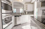 This stunning kitchen boasts modern stainless steel appliances, including a built-in oven and dishwasher, perfect for culinary enthusiasts.