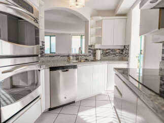 This stunning kitchen boasts modern stainless steel appliances, including a built-in oven and dishwasher, perfect for culinary enthusiasts.