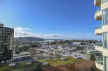 Enjoy stunning views from this modern condo, overlooking a vibrant cityscape and the serene waters.