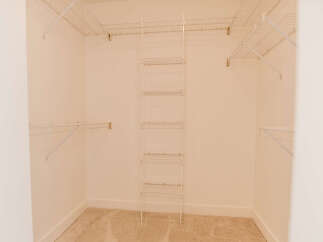 Step into this spacious walk-in closet, offering ample storage and organization.