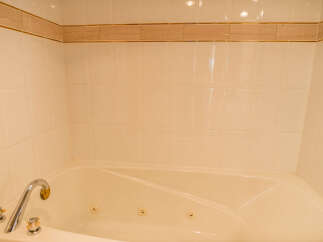 This luxurious bathroom features a spacious jacuzzi tub, perfect for relaxing after a long day.