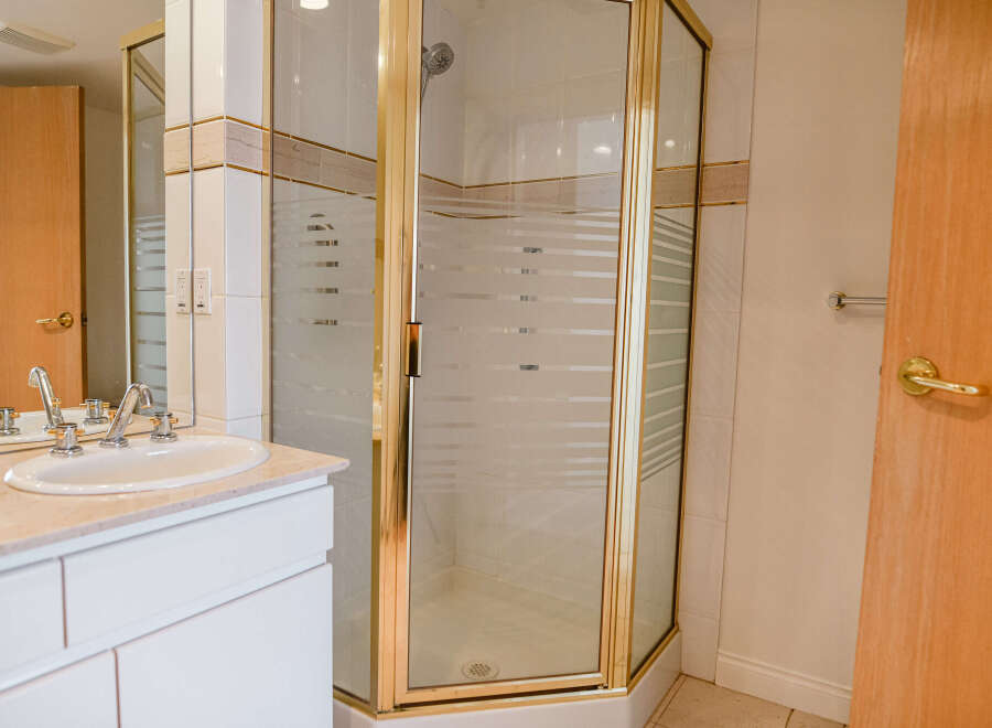 Step into a beautifully designed bathroom featuring a modern shower enclosure with a gold frame.