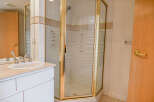Step into a beautifully designed bathroom featuring a modern shower enclosure with a gold frame.