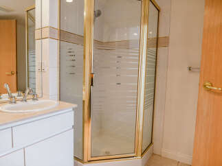 Step into a beautifully designed bathroom featuring a modern shower enclosure with a gold frame.