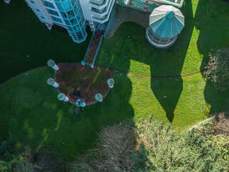 An aerial view showcases a unique property featuring a distinctive architectural design.