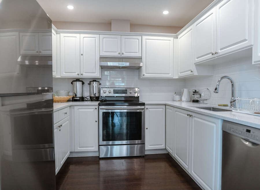 This stunning kitchen boasts a modern design with sleek white cabinetry, offering ample storage and a bright, airy feel.