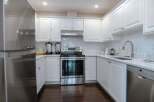 This stunning kitchen boasts a modern design with sleek white cabinetry, offering ample storage and a bright, airy feel.
