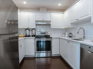This stunning kitchen boasts a modern design with sleek white cabinetry, offering ample storage and a bright, airy feel.