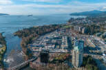 An aerial view showcases a vibrant cityscape nestled along the coast, offering a blend of urban living and natural beauty.