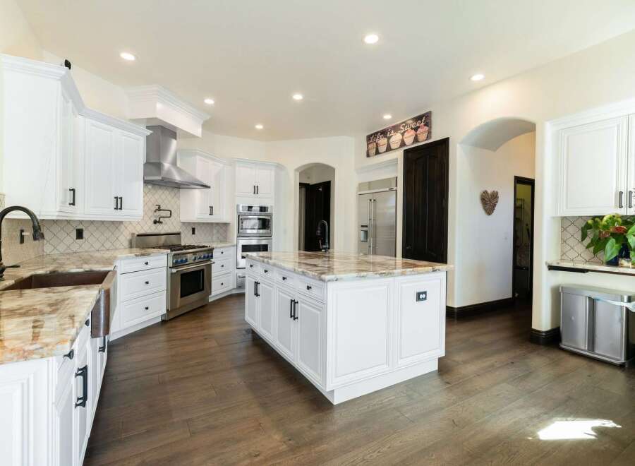 This stunning kitchen boasts a spacious island with elegant countertops, perfect for meal preparation and entertaining.