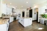 This stunning kitchen boasts a spacious island with elegant countertops, perfect for meal preparation and entertaining.