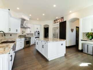 This stunning kitchen boasts a spacious island with elegant countertops, perfect for meal preparation and entertaining.