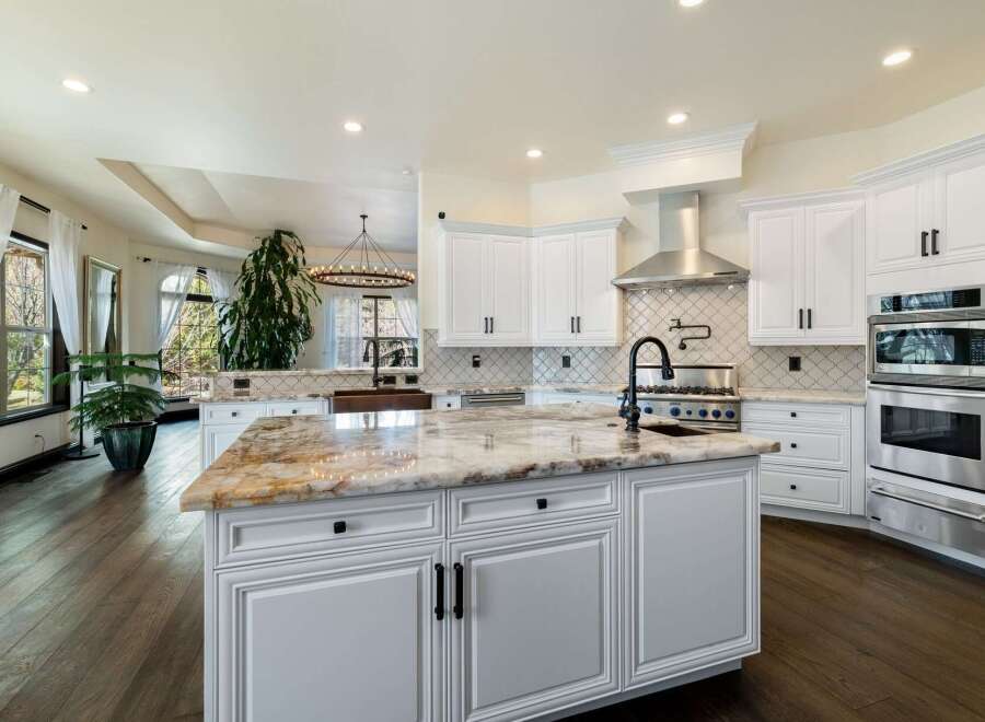This stunning kitchen boasts a luxurious island with a beautiful marble countertop, perfect for meal preparation and entertaining.
