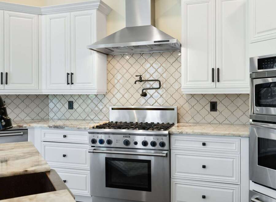This stunning kitchen boasts a modern design with sleek white cabinetry and stainless steel appliances.