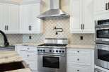 This stunning kitchen boasts a modern design with sleek white cabinetry and stainless steel appliances.