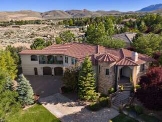 Experience luxury living in this stunning Mediterranean-style estate, boasting a distinctive red tile roof and a charming turret.