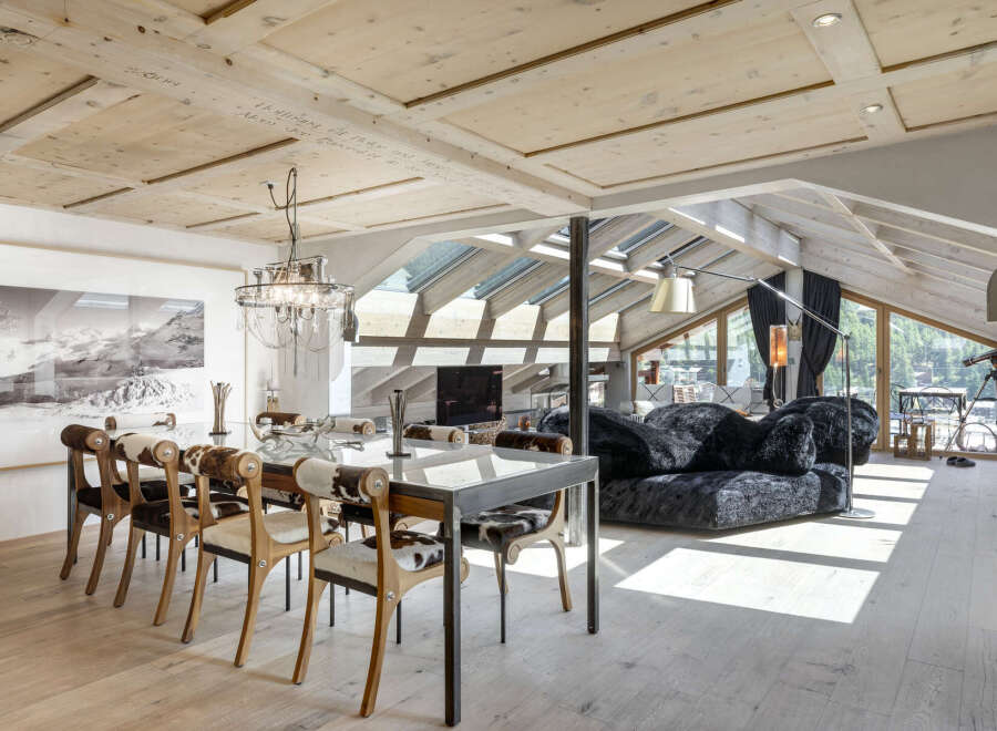 Experience luxury living in this stunning property featuring a modern dining area with a glass table and stylish cowhide chairs.