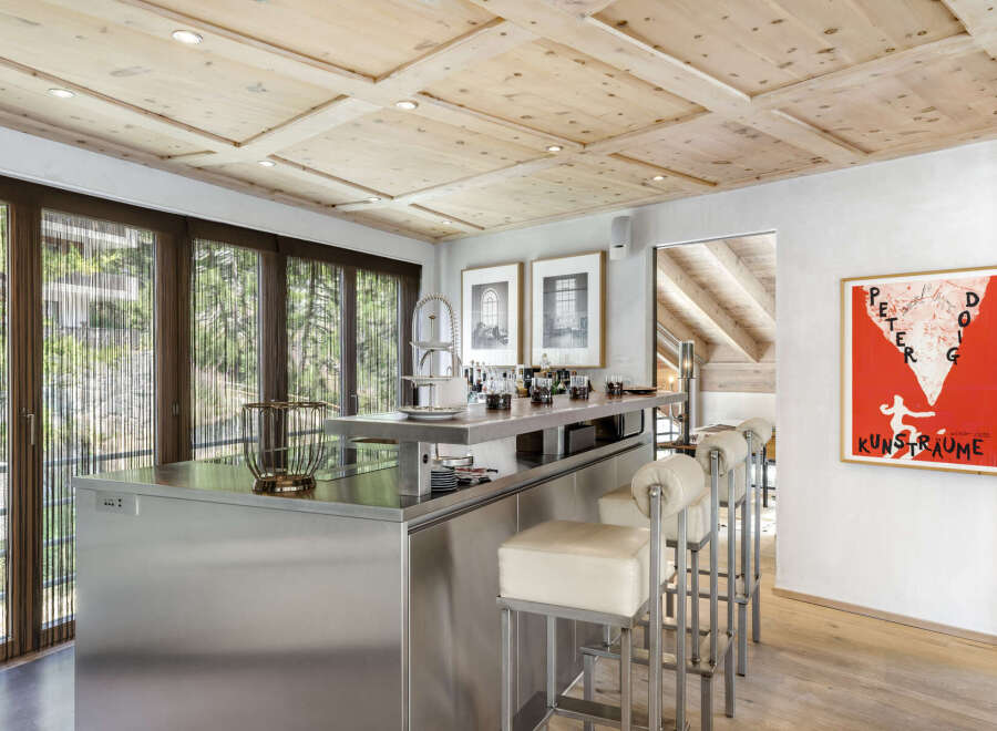 This stunning kitchen boasts a modern design with stainless steel accents and a unique wooden ceiling.