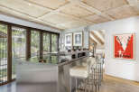 This stunning kitchen boasts a modern design with stainless steel accents and a unique wooden ceiling.