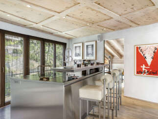 This stunning kitchen boasts a modern design with stainless steel accents and a unique wooden ceiling.