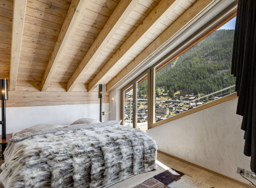 Experience the epitome of luxury in this stunning bedroom, featuring a cozy bed adorned with a plush, faux fur blanket.