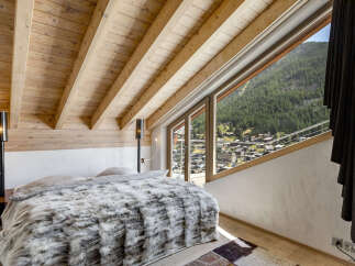 Experience the epitome of luxury in this stunning bedroom, featuring a cozy bed adorned with a plush, faux fur blanket.