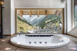 Indulge in luxury with this stunning property featuring a modern, oval-shaped bathtub.