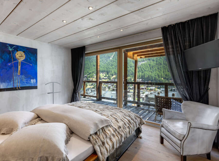 Experience luxury living in this stunning bedroom with breathtaking mountain views.
