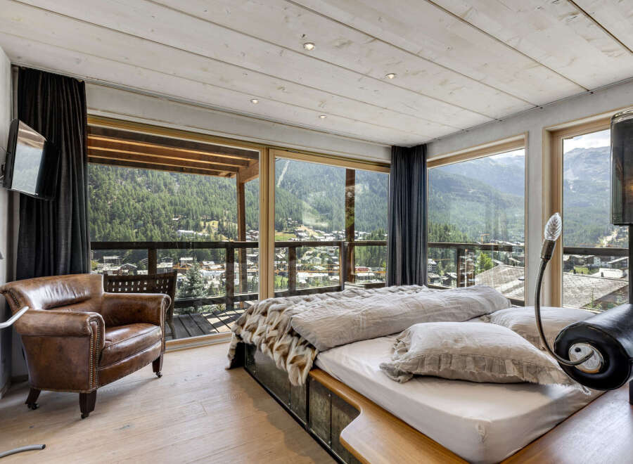 Experience luxury living in this stunning bedroom with breathtaking mountain views.